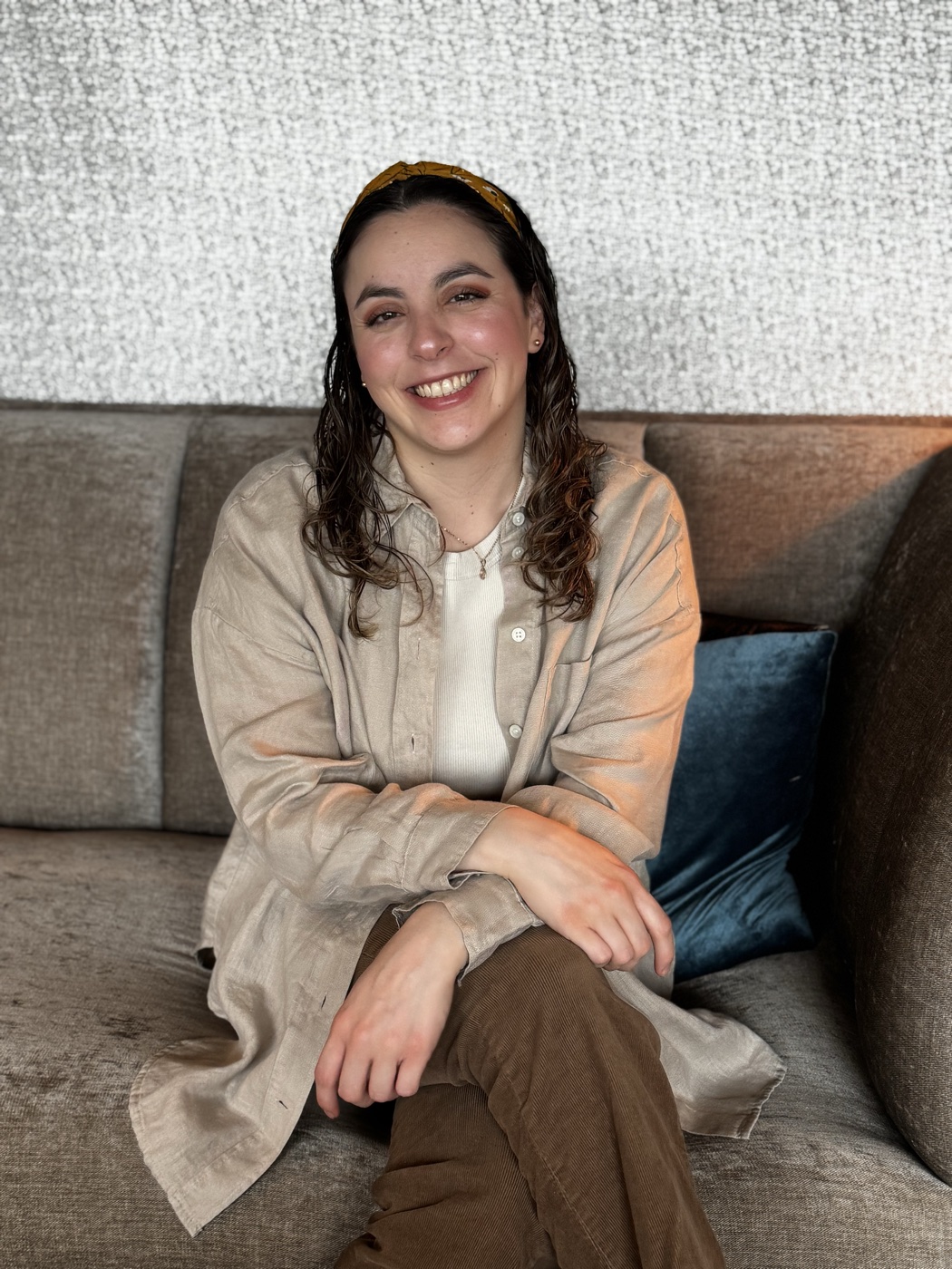 La psicóloga Alejandra Pérez sonriendo, sentada en un sofá